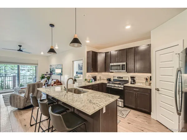 a kitchen with kitchen island granite countertop a sink appliances and cabinets