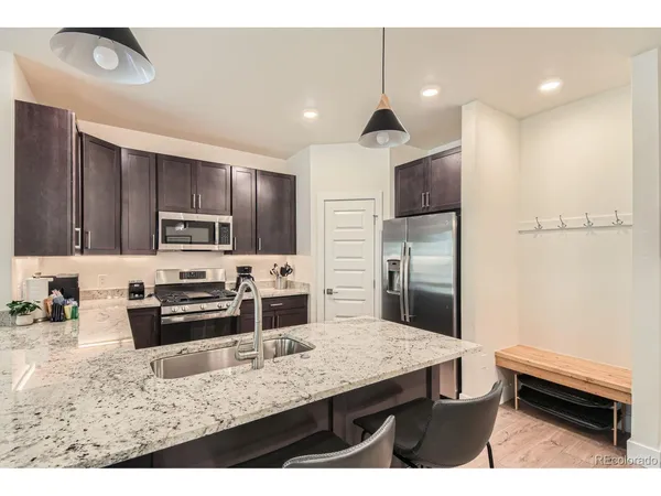a kitchen with stainless steel appliances kitchen island granite countertop a refrigerator and a stove top oven