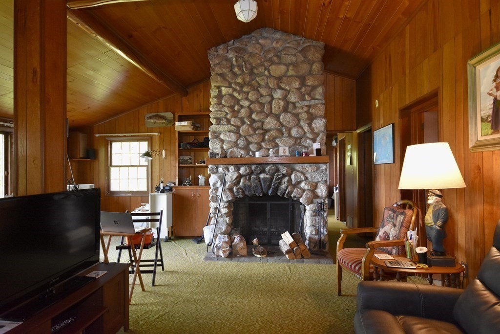 572 Snipatuit Road Rochester, MA 02770 - Photo 4 of 6 a living room with furniture a flat screen tv and a fireplace