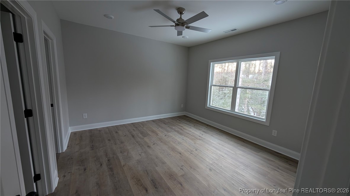5130 Cardinal Circle Sanford, NC 27332 - Photo 13 of 36 an empty room with wooden floor fan and windows