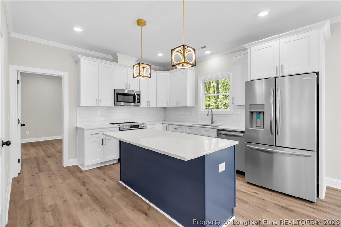 5130 Cardinal Circle Sanford, NC 27332 - Photo 10 of 45 a kitchen with a refrigerator a sink and dishwasher a stove top oven with wooden floor