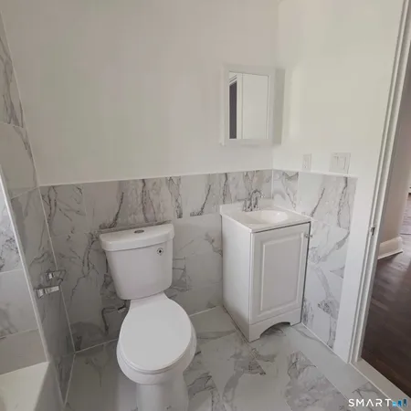 a white toilet sitting next to a white sink and vanity