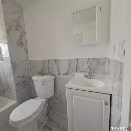 a bathroom with a sink a toilet and a mirror