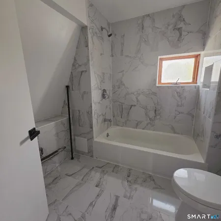 a bathroom with a toilet and a bath tub