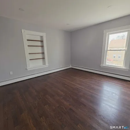 an empty room with wooden floor and window