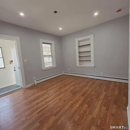 an empty room with wooden floor and windows