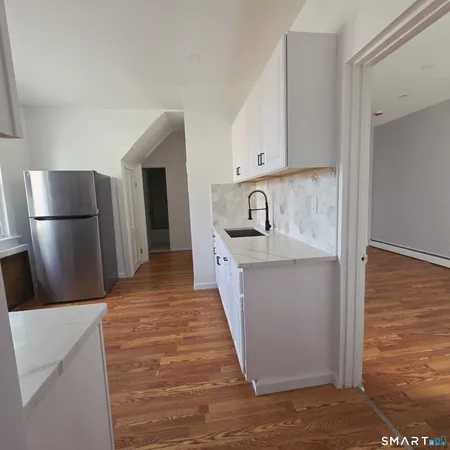 a view of a kitchen with a sink and refrigerator