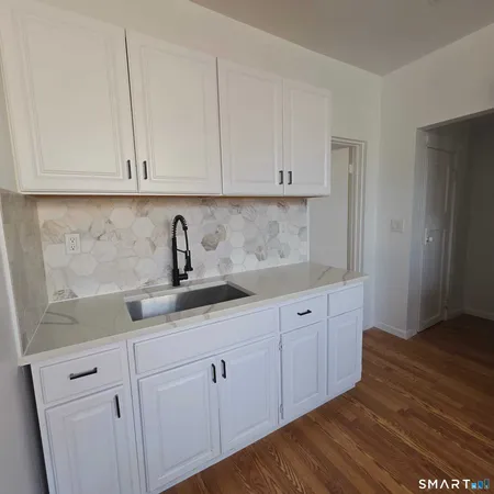 a kitchen with white cabinets and sink