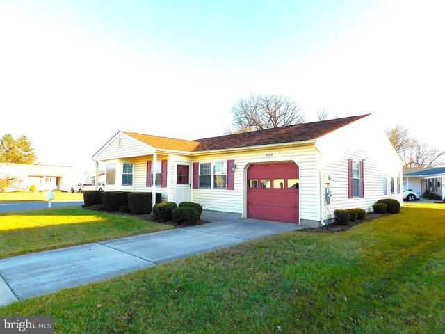 a front view of a house with a yard and swimming pool