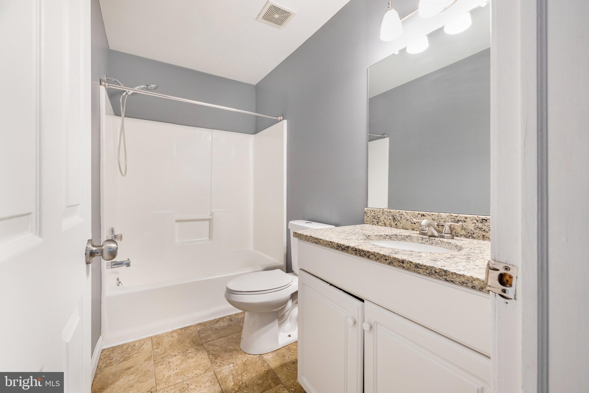 93 Nursery Drive Bear, DE 19701 - Photo 23 of 43 a bathroom with a granite countertop sink toilet mirror and a shower