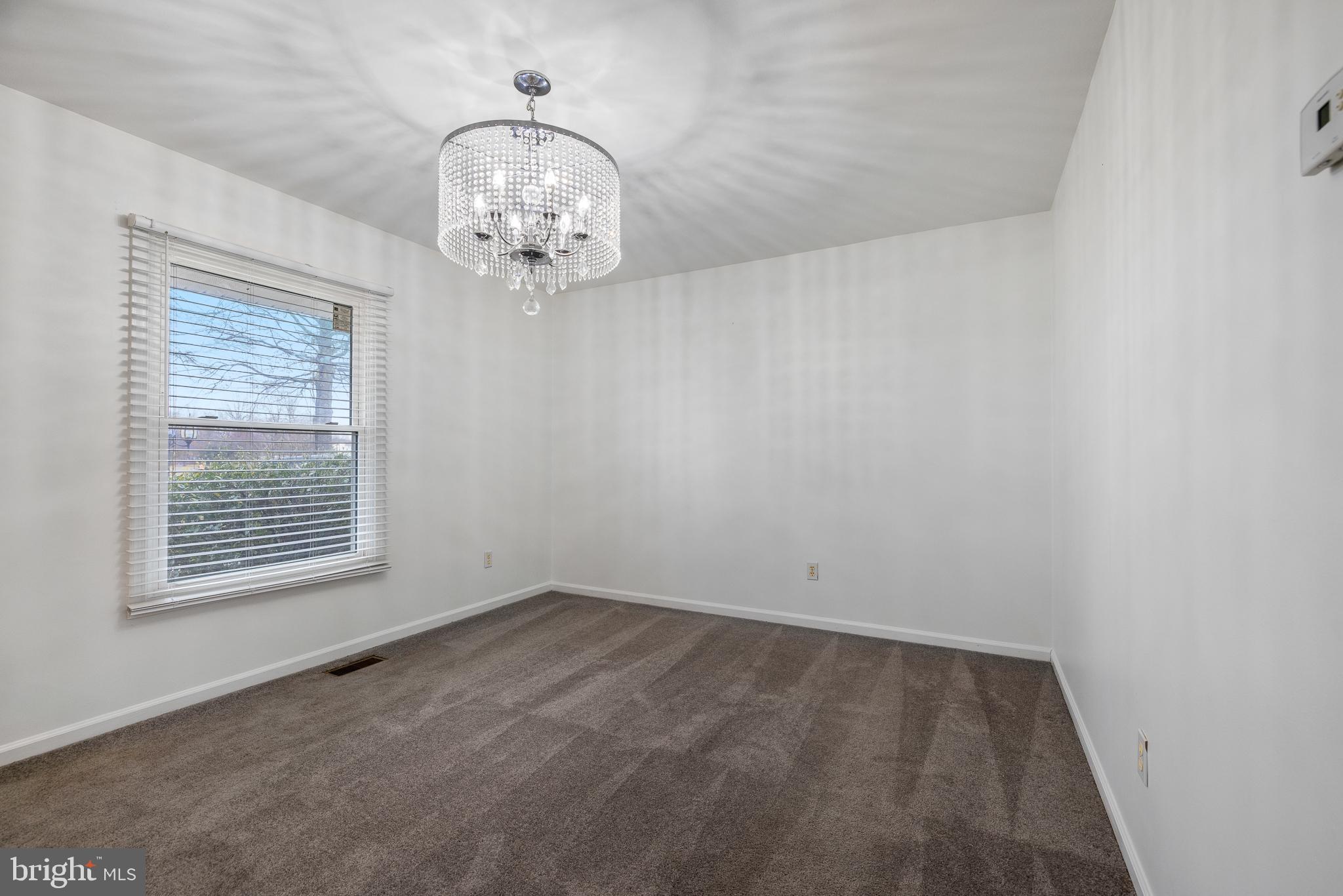 93 Nursery Drive Bear, DE 19701 - Photo 4 of 43 an empty room with a chandelier fan and wooden floor