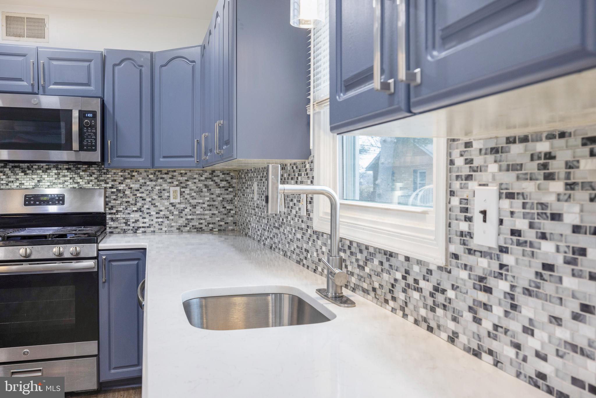 93 Nursery Drive Bear, DE 19701 - Photo 10 of 43 a kitchen with stainless steel appliances a stove a microwave and a sink