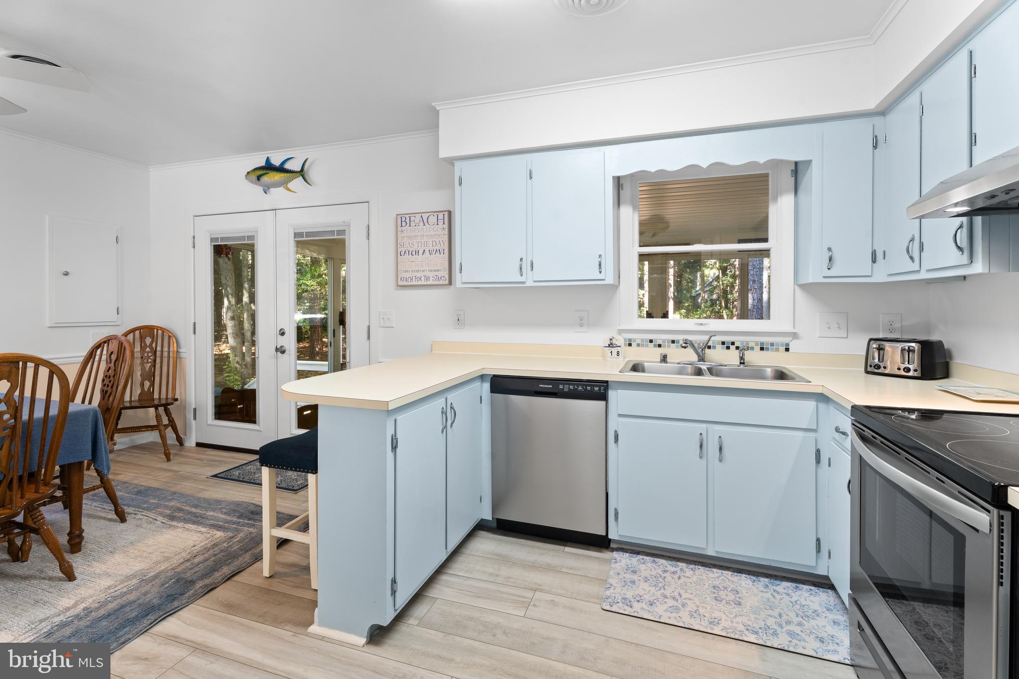 85 Ocean Parkway Ocean Pines, MD 21811 - Photo 20 of 78 a kitchen with a sink cabinets and dining table chair