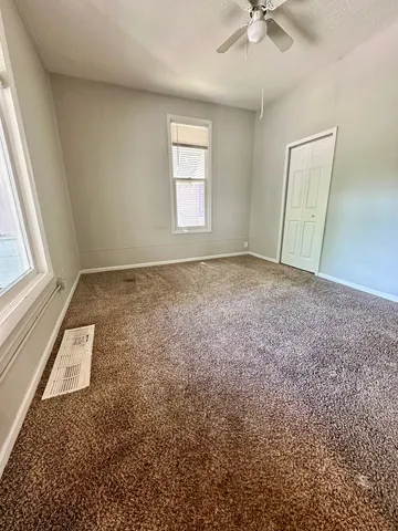 an empty room with windows and closet
