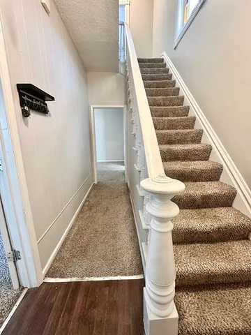 a view of entryway and hall with wooden floor