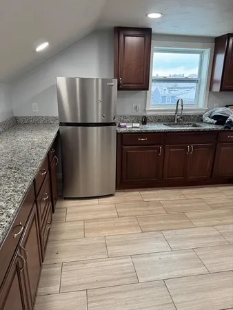 a kitchen with stainless steel appliances granite countertop a refrigerator a sink and a stove