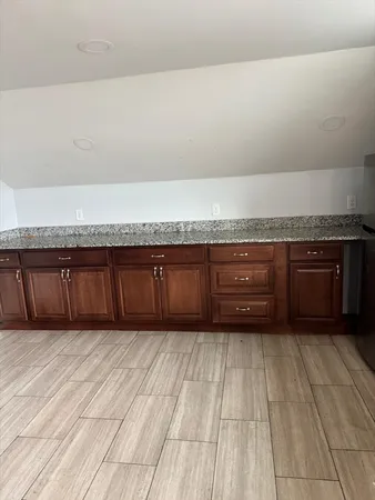 a view of a kitchen with an empty space and wooden floor