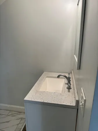 a bathroom with a granite countertop sink and vanity