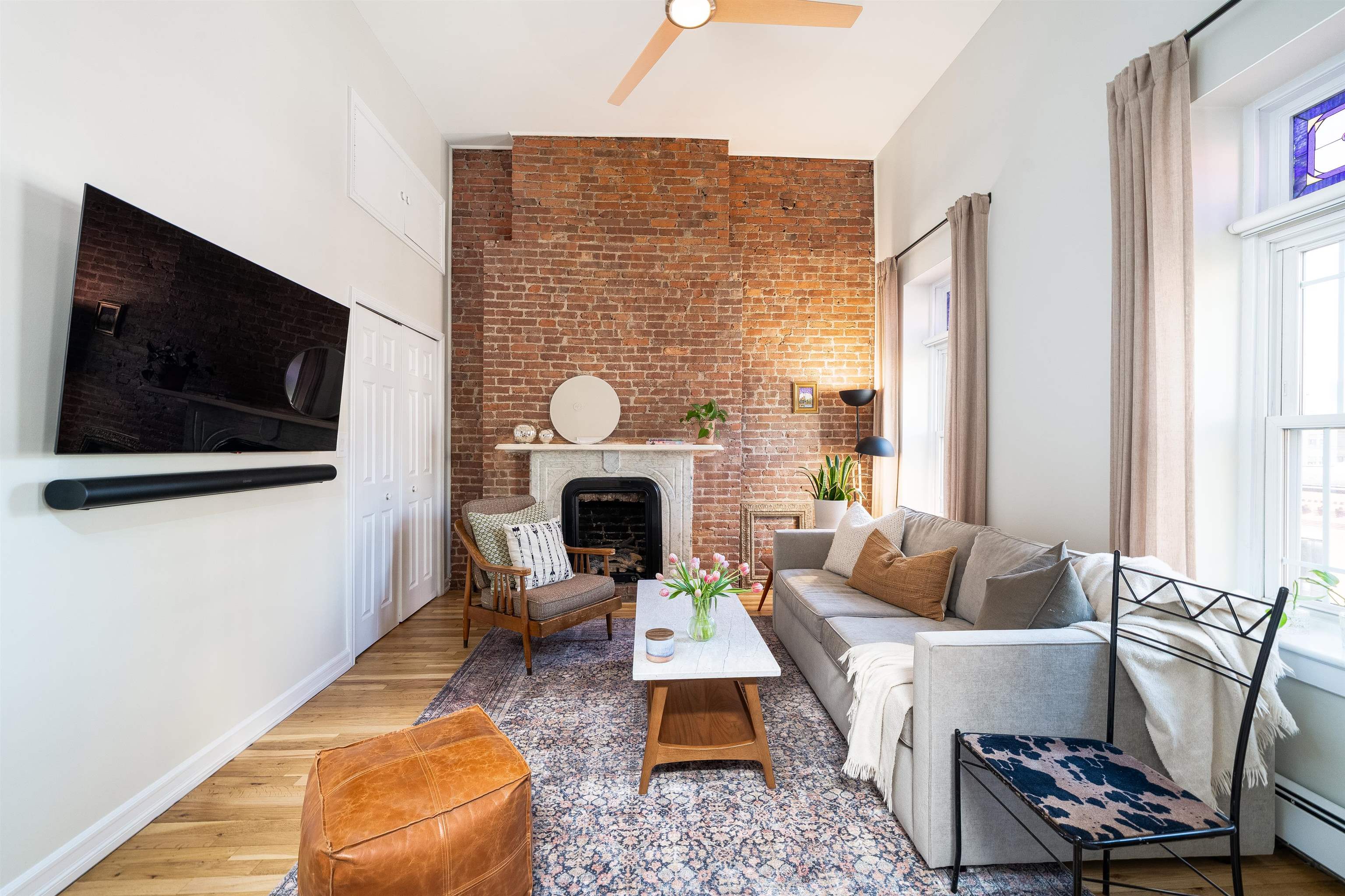 205 14th Street, Unit 4F Hoboken, NJ 07030 - Photo 3 of 22 a living room with furniture a flat screen tv and a fireplace
