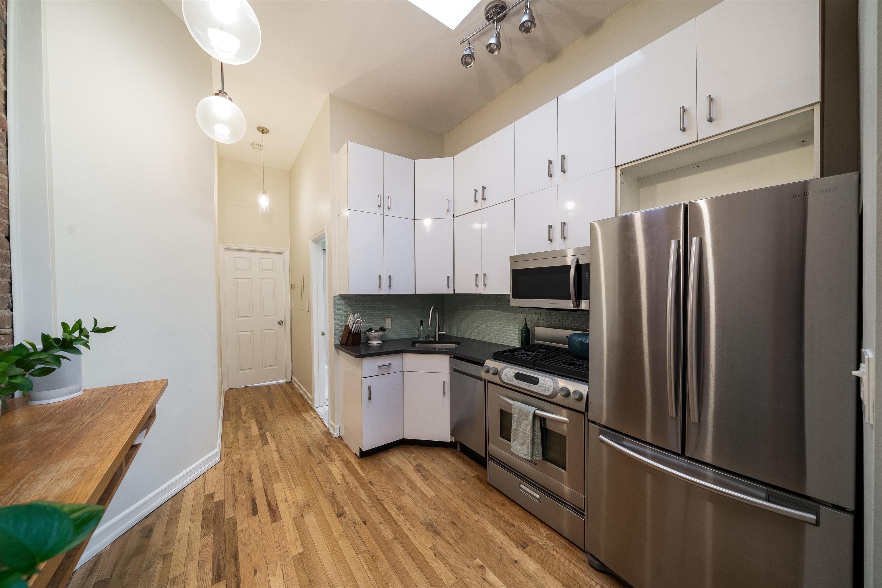 205 14th Street, Unit 4F Hoboken, NJ 07030 - Photo 10 of 22 a kitchen with stainless steel appliances a refrigerator sink and stove