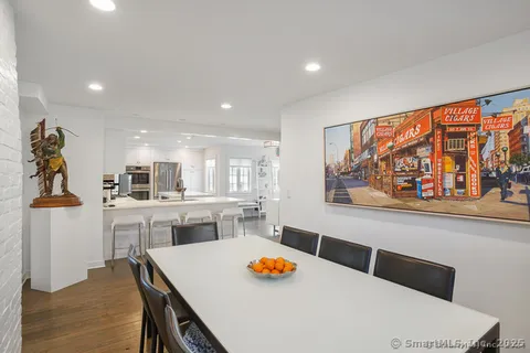 a living room with stainless steel appliances kitchen island granite countertop furniture and a wooden floor