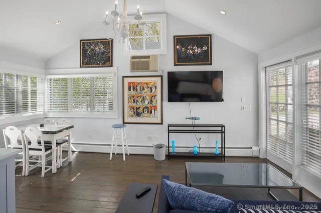 a living room with furniture a flat screen tv and a large window
