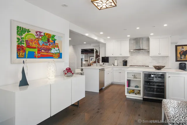 a kitchen with stainless steel appliances a microwave a stove and white cabinets