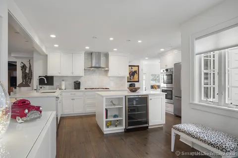 a kitchen with white cabinets and stove top oven