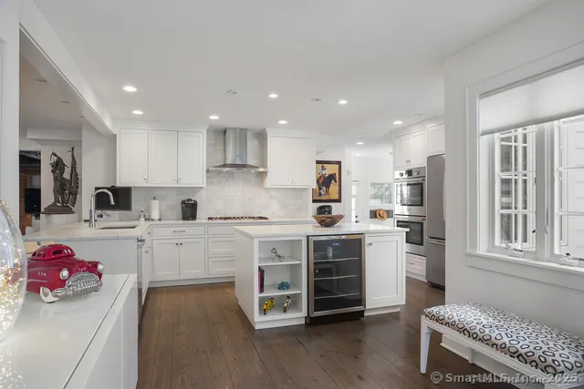 a kitchen with white cabinets and stove top oven