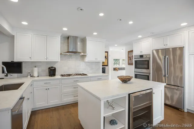 a kitchen with a refrigerator a stove top oven a sink and cabinets
