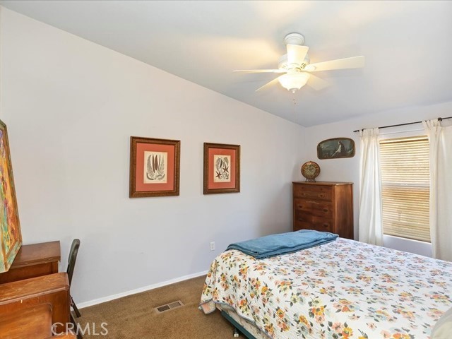 40410 Exa Ely Road Hemet, CA 92544 - Photo 25 of 74 a bedroom with a bed and a chandelier