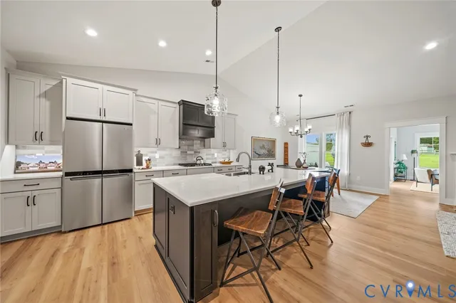 a kitchen with kitchen island a sink appliances and white cabinets