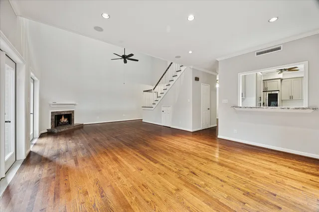 an empty room with wooden floor and a fireplace