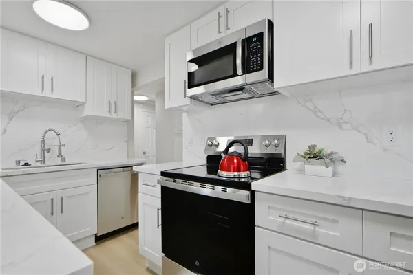 a kitchen with stainless steel appliances granite countertop a sink and a microwave