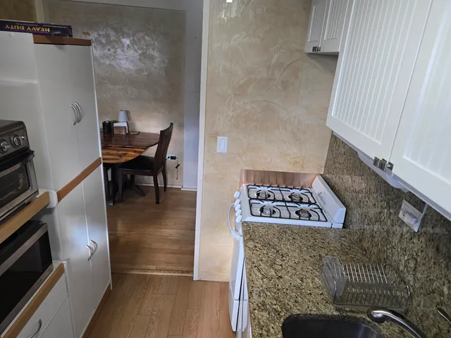 a view of a hallway with wooden floor and entryway