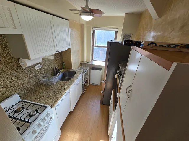 a kitchen with stainless steel appliances granite countertop a refrigerator a stove and a sink