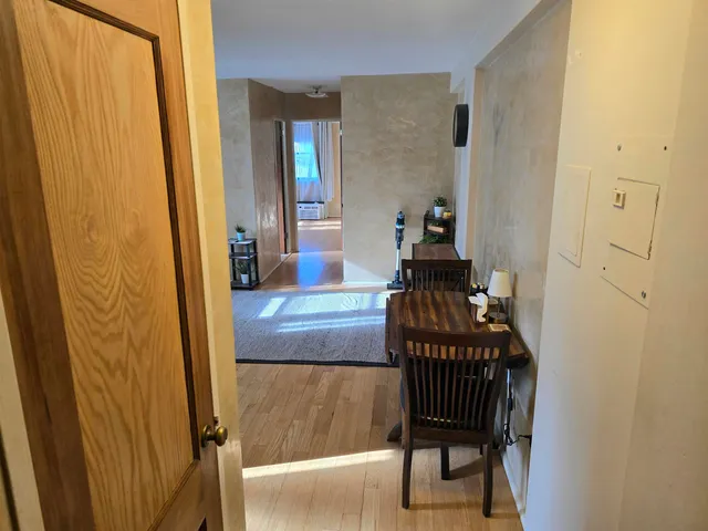 a view of a hallway with wooden floor windows and a livingroom
