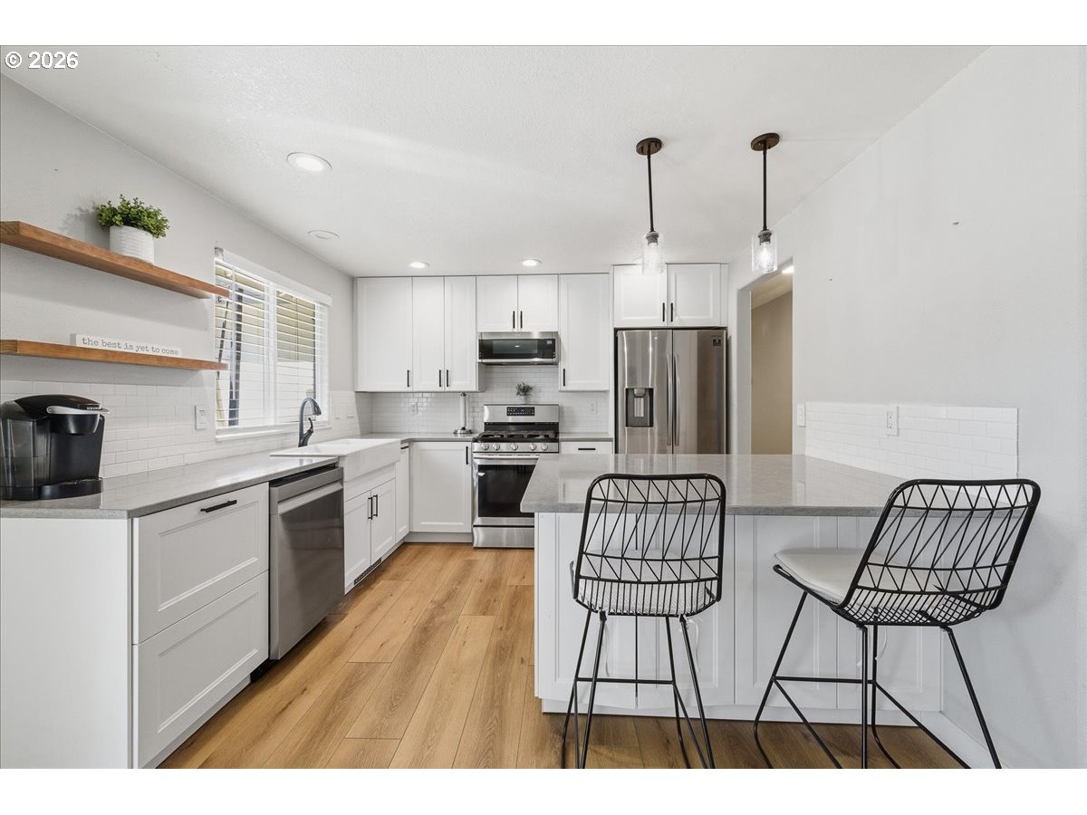 18988 Southwest Pike Lane Beaverton, OR 97078 - Photo 11 of 36 a kitchen with stainless steel appliances kitchen island granite countertop a sink and cabinets