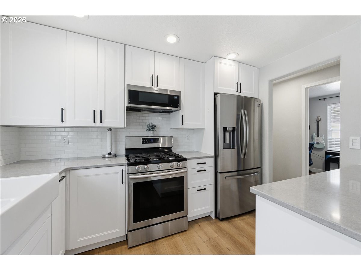 18988 Southwest Pike Lane Beaverton, OR 97078 - Photo 13 of 36 a kitchen with stainless steel appliances granite countertop a stove a refrigerator and a microwave