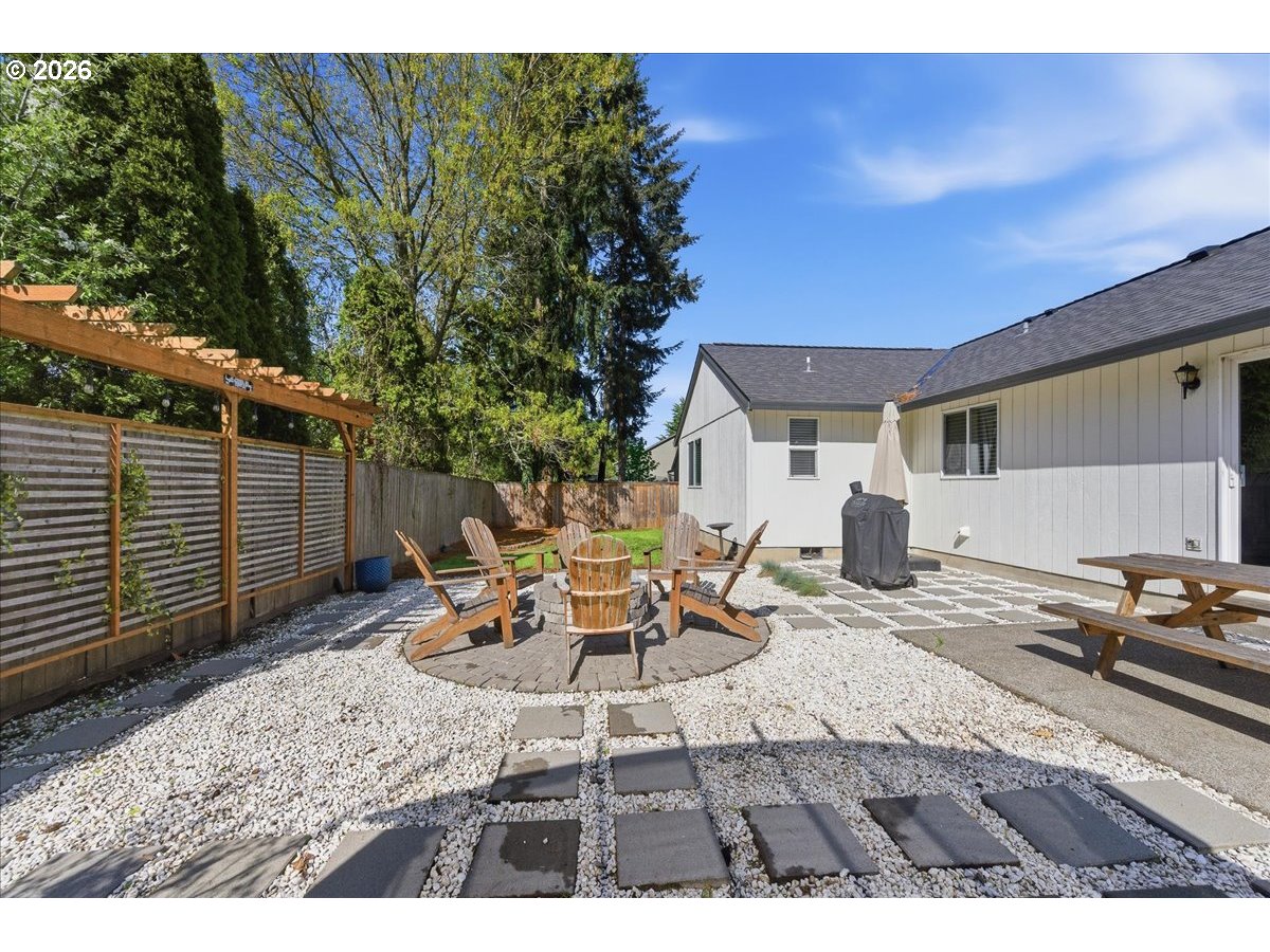 18988 Southwest Pike Lane Beaverton, OR 97078 - Photo 33 of 36 a view of a backyard with table and chairs and wooden fence
