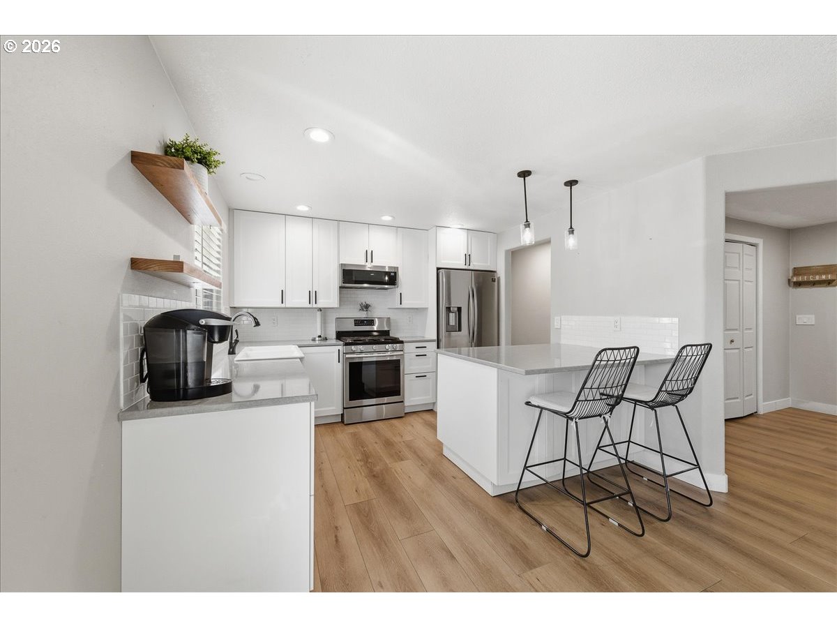 18988 Southwest Pike Lane Beaverton, OR 97078 - Photo 10 of 36 a kitchen with stainless steel appliances wooden floors and wooden cabinets