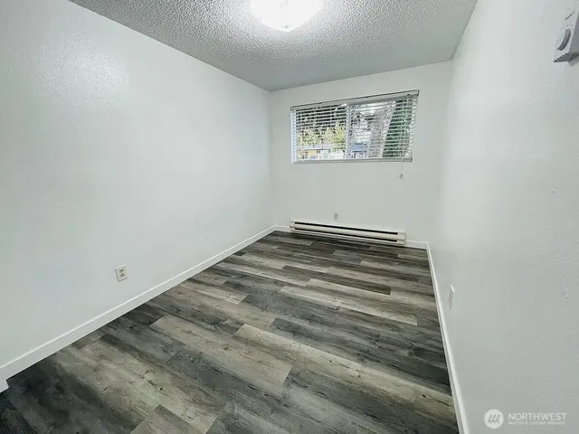 a view of a room with wooden floor and window