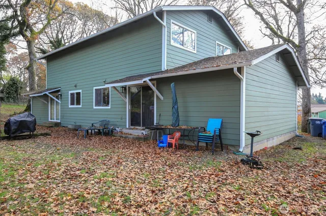 a view of a house with a yard chairs and floor to ceiling window