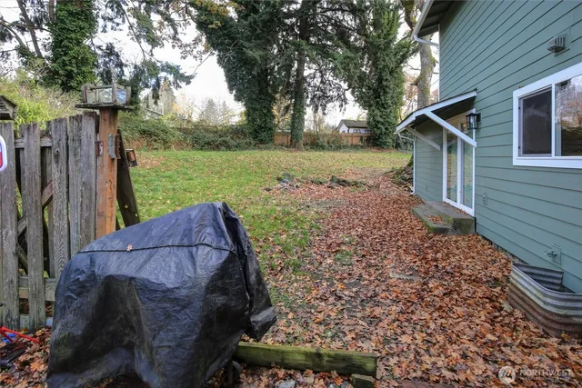 a view of a backyard with barn and wooden fence
