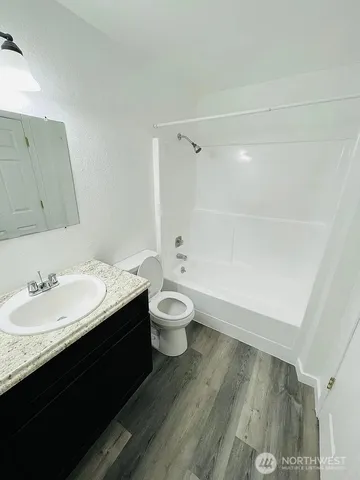 a bathroom with a granite countertop sink toilet a large mirror and shower