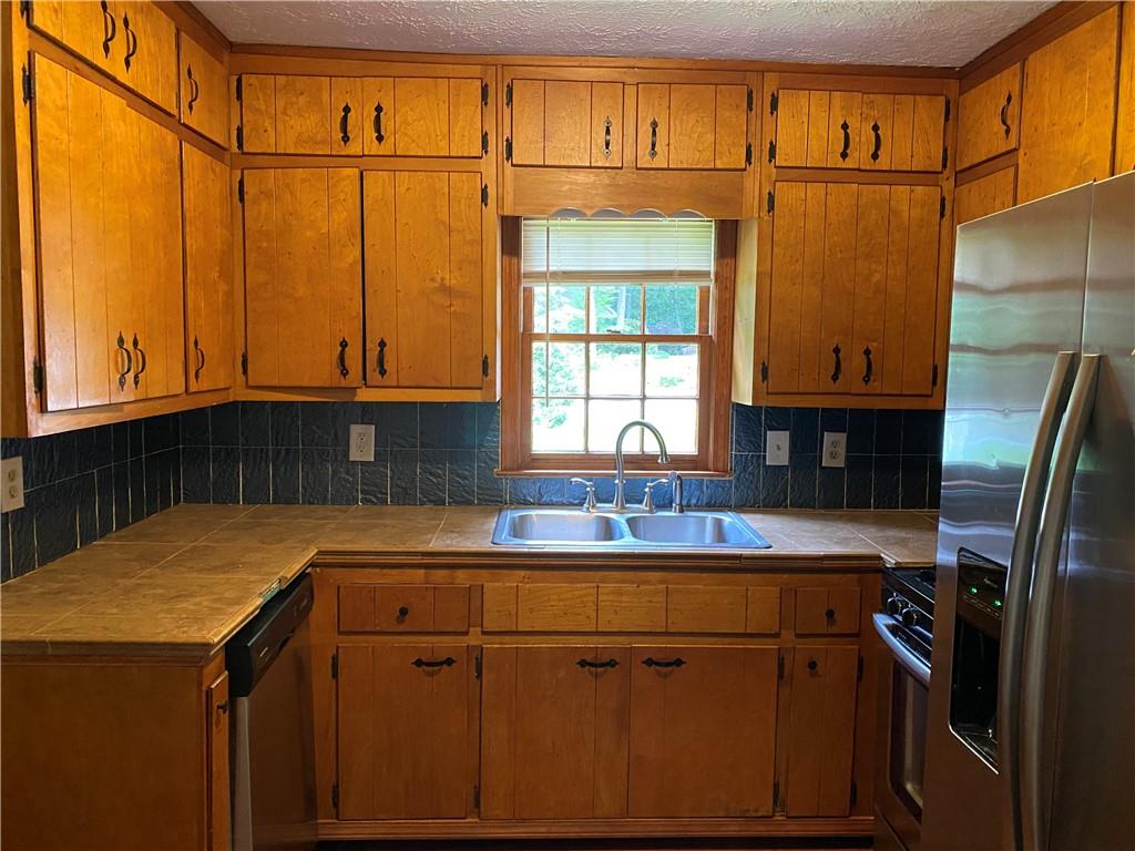 207 Hood Road Northwest Lilburn, GA 30047 - Photo 7 of 12 a kitchen with stainless steel appliances a refrigerator and a sink