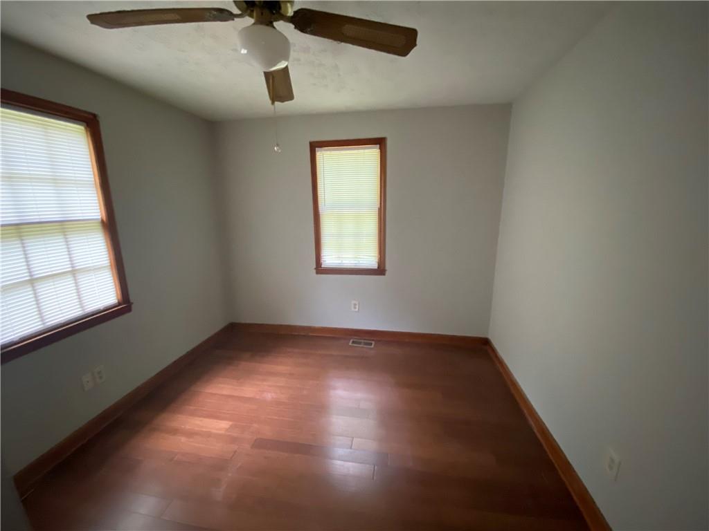 207 Hood Road Northwest Lilburn, GA 30047 - Photo 8 of 12 an empty room with windows and fan