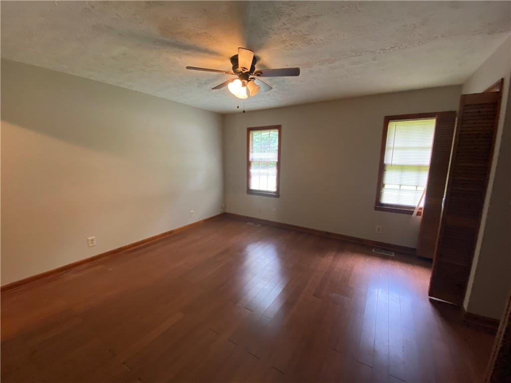 207 Hood Road Northwest Lilburn, GA 30047 - Photo 9 of 12 a view of empty room with wooden floor and fan