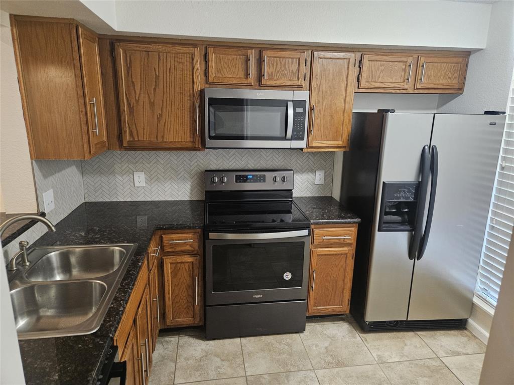 9601 Forest Lane, Unit 224 Dallas, TX 75243 - Photo 1 of 17 a kitchen with granite countertop a refrigerator stove and microwave