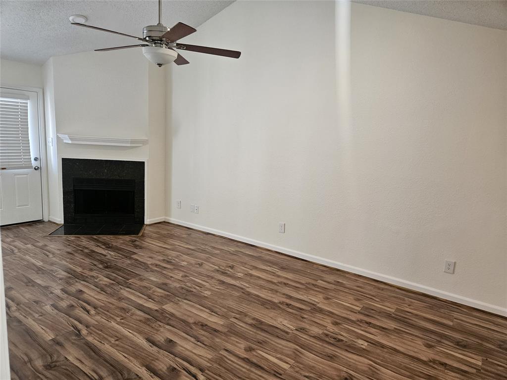 9601 Forest Lane, Unit 224 Dallas, TX 75243 - Photo 13 of 17 a view of empty room with wooden floor and fireplace